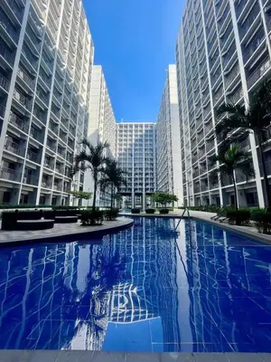 a large swimming pool in a city with tall buildings at Staycation bliss! Shore 2 B1! in Manila
