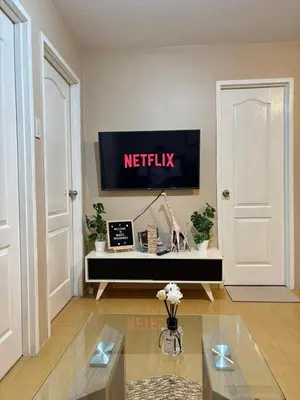 a living room with a television on a wall at Cozy 2BR Condo Free Pool Access in Manila