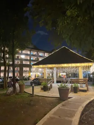 a building with lights in a park at night at Cozy 2BR Condo Free Pool Access in Manila