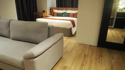 a hotel room with a bed and a couch at Novel Hotel Manila in Manila
