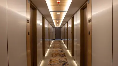 a hallway with a long aisle with a rug at Novel Hotel Manila in Manila