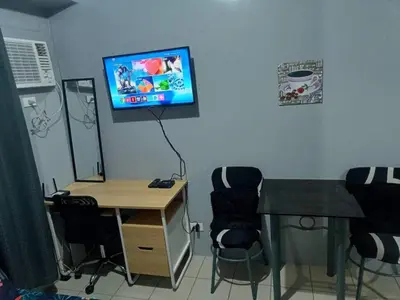a room with a desk and a tv on the wall at Berto's Staycation Long Term and Short Term in Manila