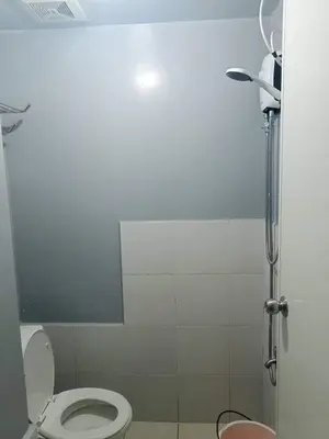 a bathroom with a toilet and a shower at Berto's Staycation Long Term and Short Term in Manila