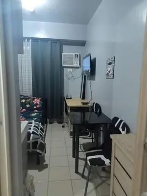 a room with a desk and a bed with a computer at Berto's Staycation Long Term and Short Term in Manila