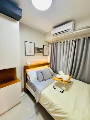 a small bedroom with a bed and a table at hearth of ember 3 Shore 3 Res in Manila