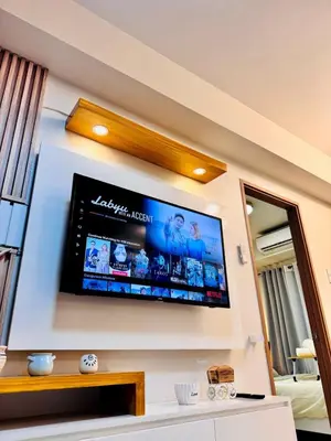 a flat screen tv on a wall in a living room at hearth of ember 3 Shore 3 Res in Manila