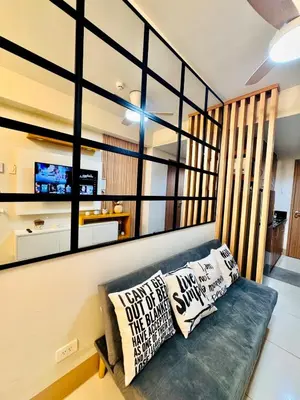a living room with a couch with pillows on it at hearth of ember 3 Shore 3 Res in Manila