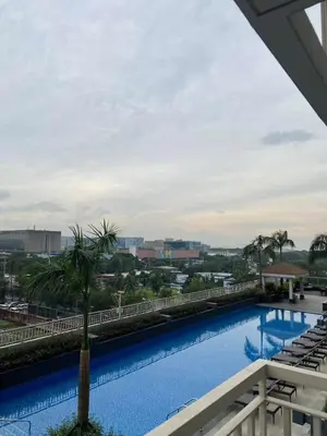 a view of a large swimming pool with a palm tree at FX Condotel 3322 in Manila