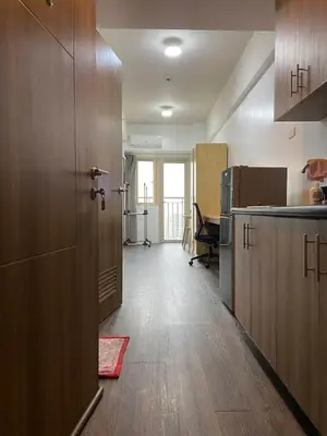 a kitchen with wooden cabinets and a door in a room at FX Condotel 3322 in Manila
