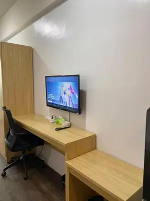 a room with a desk with a tv and a computer at FX Condotel 3322 in Manila