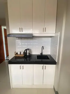 a kitchen with white cabinets and a sink at Santipha Residences in Manila
