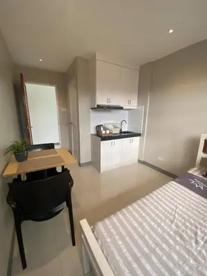 a room with a bed and a desk and a kitchen at Santipha Residences in Manila