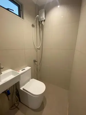 a white bathroom with a toilet and a sink at Santipha Residences in Manila
