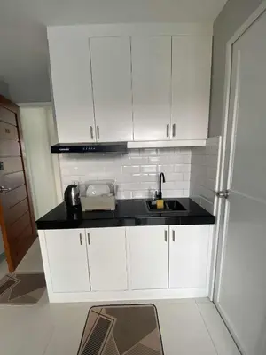 a kitchen with white cabinets and a sink at Santipha Residences in Manila