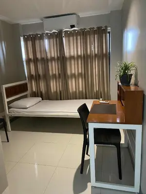 a small room with a bed and a desk at Santipha Residences in Manila