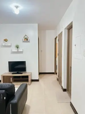 a living room with a couch and a television at Alea Residence 21 in Manila