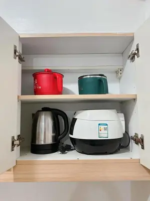 a microwave and a toaster on a shelf in a kitchen at Alea Residence 21 in Manila