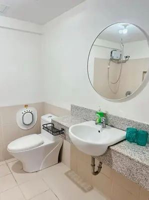 a bathroom with a toilet and a sink and a mirror at Alea Residence 21 in Manila