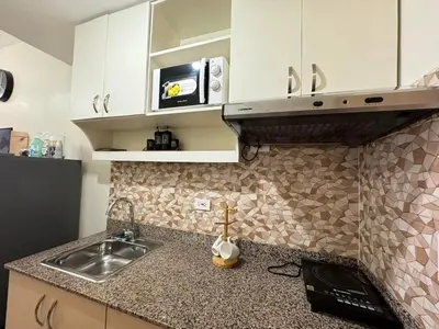 a kitchen with a sink and a microwave at Staycation at Field Residences Near Airport in Manila