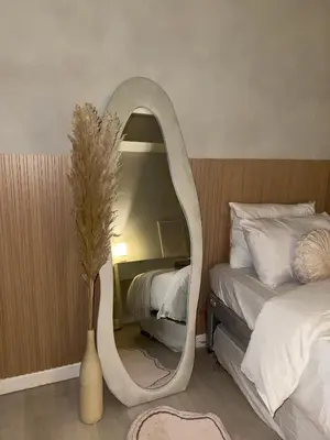 a mirror in a bedroom with a bed and a vase at 2BR - Azure Staycation Parañaque in Manila