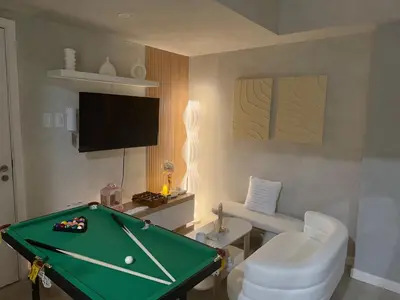a living room with a pool table and a television at 2BR - Azure Staycation Parañaque in Manila