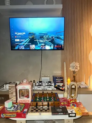 a tv hanging on a wall above a table with a chess board at 2BR - Azure Staycation Parañaque in Manila