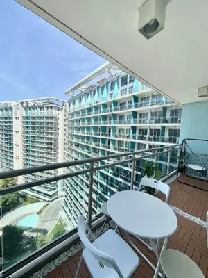 a balcony with a table and chairs and a large building at 2BR - Azure Staycation Parañaque in Manila