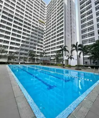 a large blue swimming pool in front of tall buildings at Luxury for Less next to BGC and Makati CBD in Manila