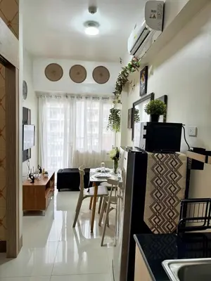 a kitchen and living room with a table and a refrigerator at 2BR Condo Staycation NearAirport in Manila