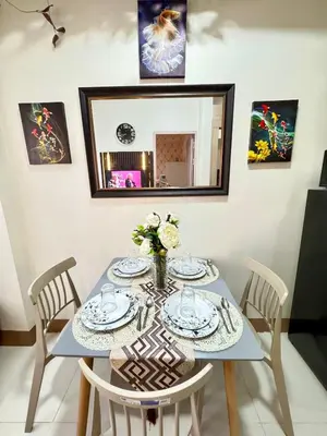 a dining room table with chairs and a mirror at 2BR Condo Staycation NearAirport in Manila