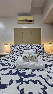 a bedroom with a large bed with a blue and white blanket at Your HOME away from home in Manila