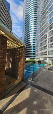 a pool in the middle of a city with tall buildings at Your HOME away from home in Manila