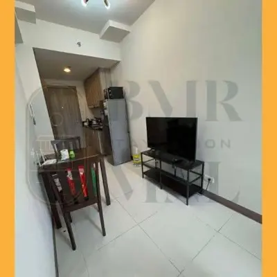 a living room with a large sign on the wall at Staycation BMR Mnl at Coast Residences in Manila