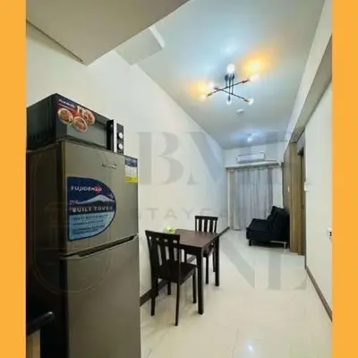 a kitchen and dining room with a table and a refrigerator at Staycation BMR Mnl at Coast Residences in Manila