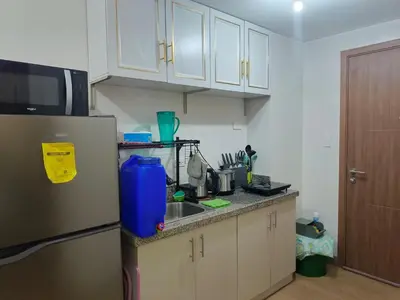 a kitchen with a refrigerator and a sink at Charles Haven's Crib - Spring Residences in Manila