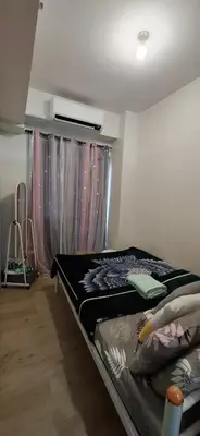a bedroom with a bed and a window with curtains at Charles Haven's Crib - Spring Residences in Manila