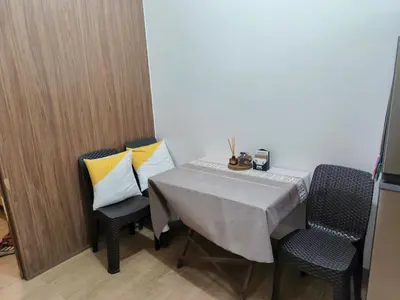a dining room table with two chairs and a table with pillows at Charles Haven's Crib - Spring Residences in Manila