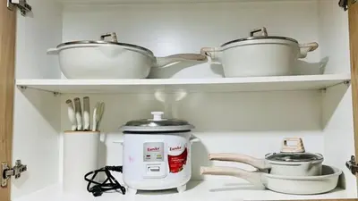 two pots and pans on shelves in a kitchen at Namrata staycation in Manila