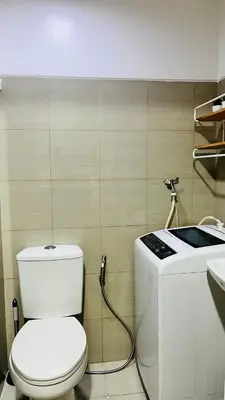 a bathroom with a white toilet and a sink at Namrata staycation in Manila