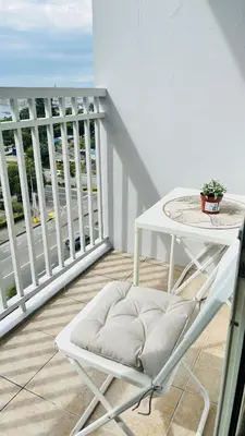 a white chair and a table on a balcony at Namrata staycation in Manila
