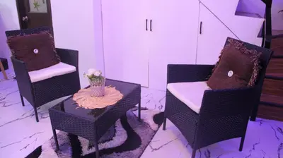 a room with three chairs and a table with a vase of flowers at Phoenix Bliss - Amber in General Trias