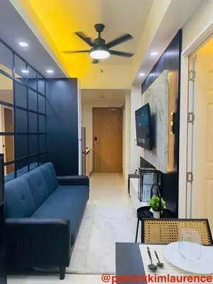 a living room with a blue couch and a ceiling at Shore 3 - 1BR Scandi-Industrial Condo Suite by The Bay in Manila