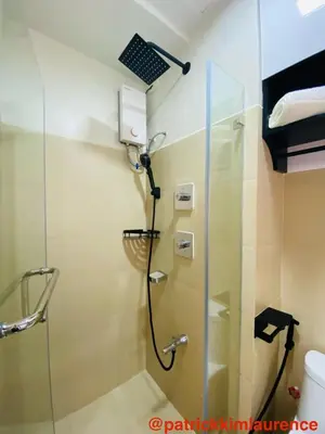 a shower in a bathroom with a glass door at Shore 3 - 1BR Scandi-Industrial Condo Suite by The Bay in Manila