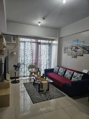 a living room with a couch and a table at Unit 14E Tower D, 1BR Unit- Manhattan Heights Cubao in Manila