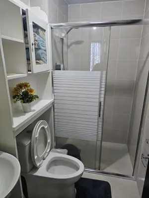 a bathroom with a toilet and a glass shower at Unit 14E Tower D, 1BR Unit- Manhattan Heights Cubao in Manila
