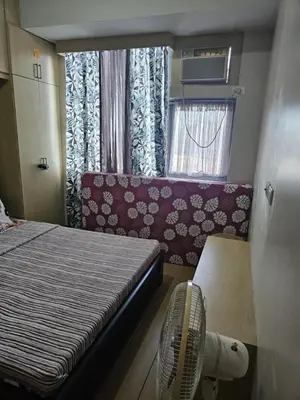 a room with a bed and a fan and a window at Unit 14E Tower D, 1BR Unit- Manhattan Heights Cubao in Manila