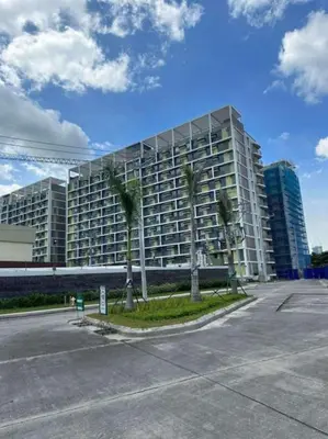 a large building with palm trees in front of it at 2 bedroom unit near BGC Taguig and NAIA Airport in Manila