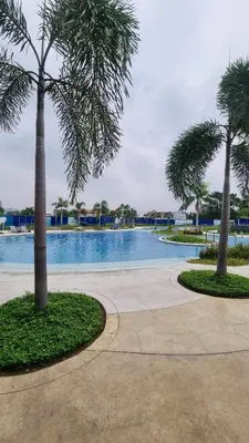 a swimming pool with palm trees and a sidewalk at 2 bedroom unit near BGC Taguig and NAIA Airport in Manila