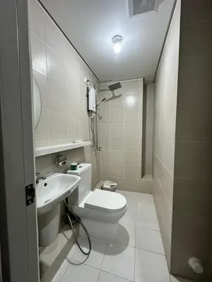 a bathroom with a toilet and a sink at 2 bedroom unit near BGC Taguig and NAIA Airport in Manila