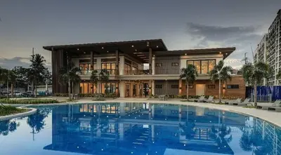 a large house with a large pool in front of it at 2 bedroom unit near BGC Taguig and NAIA Airport in Manila